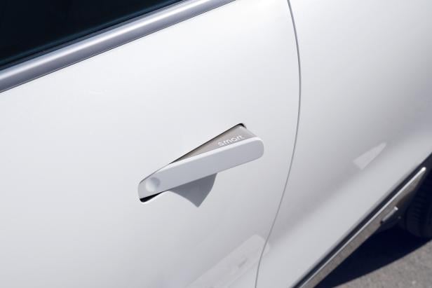 Detailansicht des Türgriffs eines weißen Smart-Autos.