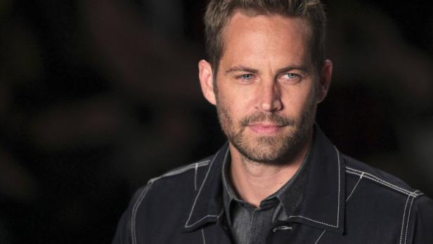 U.S. actor Walker presents a creation from Colcci' Porträt des Schauspielers Paul Walker vor einem dunklen Hintergrund.