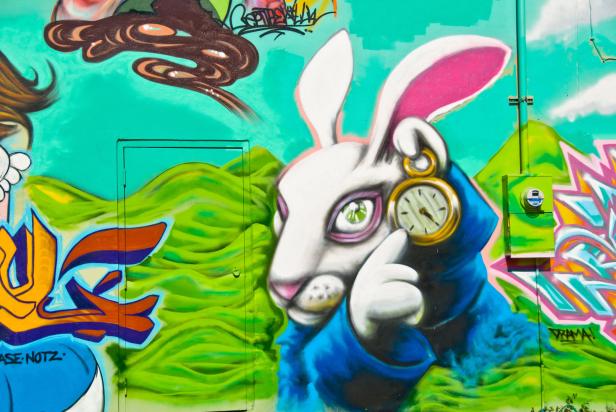 Ein Graffiti zeigt das weiße Kaninchen aus „Alice im Wunderland“ mit einer goldenen Taschenuhr.