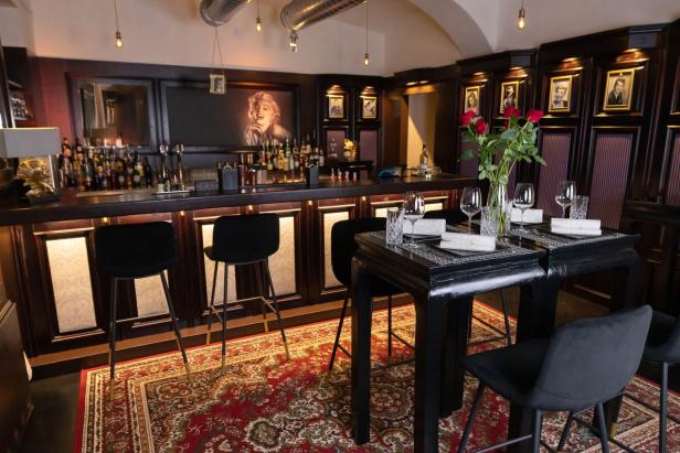 Eine Bar mit Hockern und gedeckten Tischen, dekoriert mit einem Porträt von Marilyn Monroe.