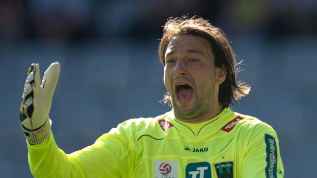 Ein Torwart in gelber Sportkleidung und Handschuhen schreit auf dem Fußballfeld.