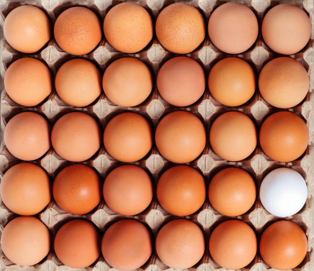 Brown white fresh chicken eggs in the paperboard container. Top view