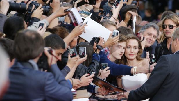 Angelina Jolie posiert mit Fans und gibt Autogramme.