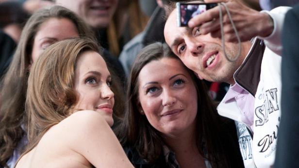 Angelina Jolie posiert für ein Selfie mit Fans.