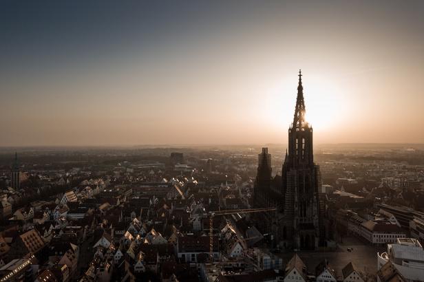 Der Ulmer Münster ragt bei Sonnenuntergang über die Stadt hinaus.