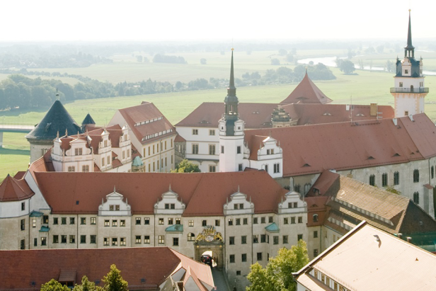 Blick auf Schloss Hartenfels in Torgau mit seinen roten Dächern und Türmen.