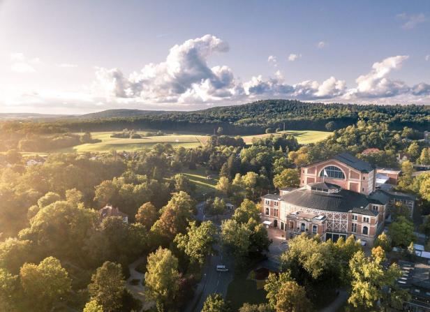 Luftaufnahme des Theaters Baden-Baden, umgeben von Bäumen und Feldern.