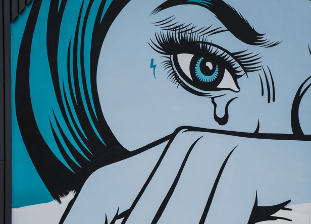 Ein blaues Pop-Art-Gemälde einer weinenden Frau mit einem Blitz unter dem Auge.