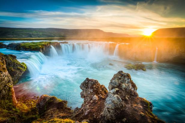 Sonnenaufgang über dem tosenden Wasserfall Islands.