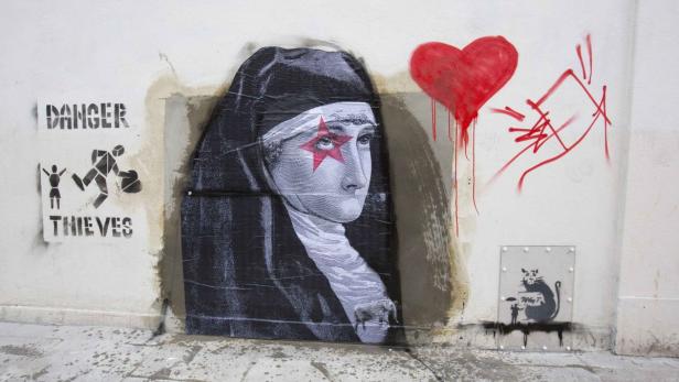 Ein Wandgemälde zeigt eine Nonne mit einem roten Stern auf dem Auge, ein rotes Herz und die Warnung „Danger Thieves“.