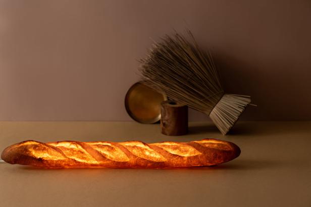 Eine leuchtende Baguette-Lampe liegt auf einem Tisch.