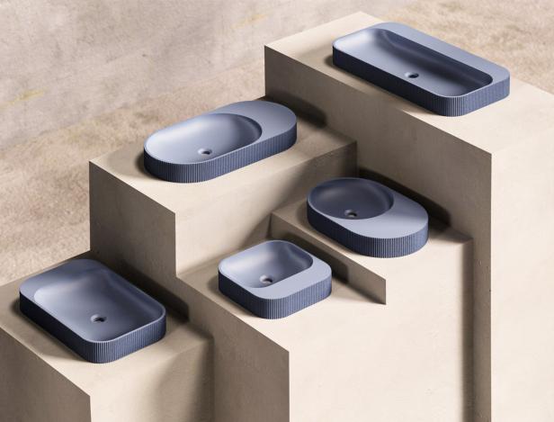 Verschiedene blaue Waschbecken in unterschiedlichen Formen sind auf einer Treppe ausgestellt.
