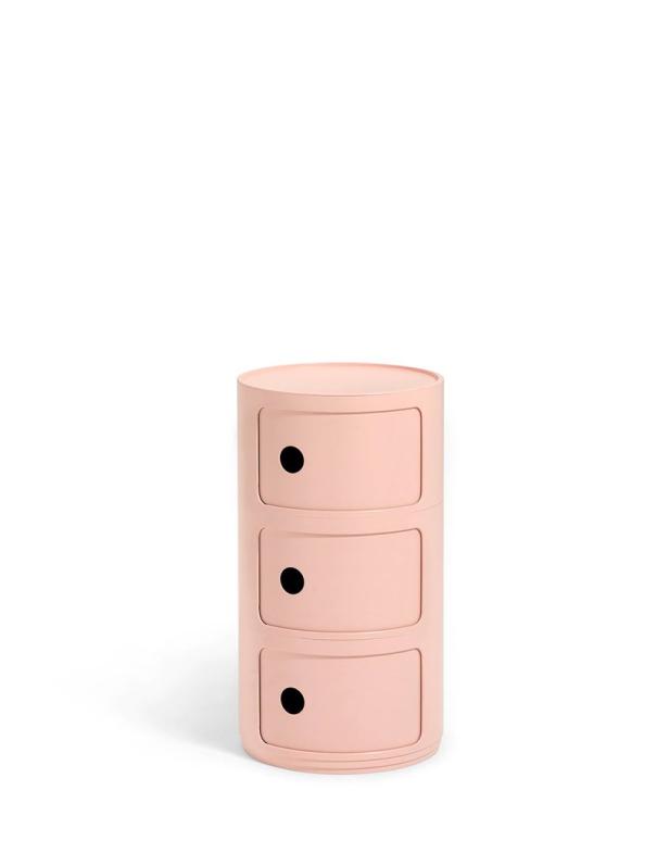 Ein rosa, zylinderförmiger Nachttisch mit drei Schubladen steht vor einem weißen Hintergrund.