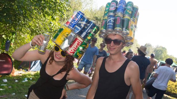Zwei Personen mit Sonnenbrillen und Hüten aus Bierdosen auf einem Festival.