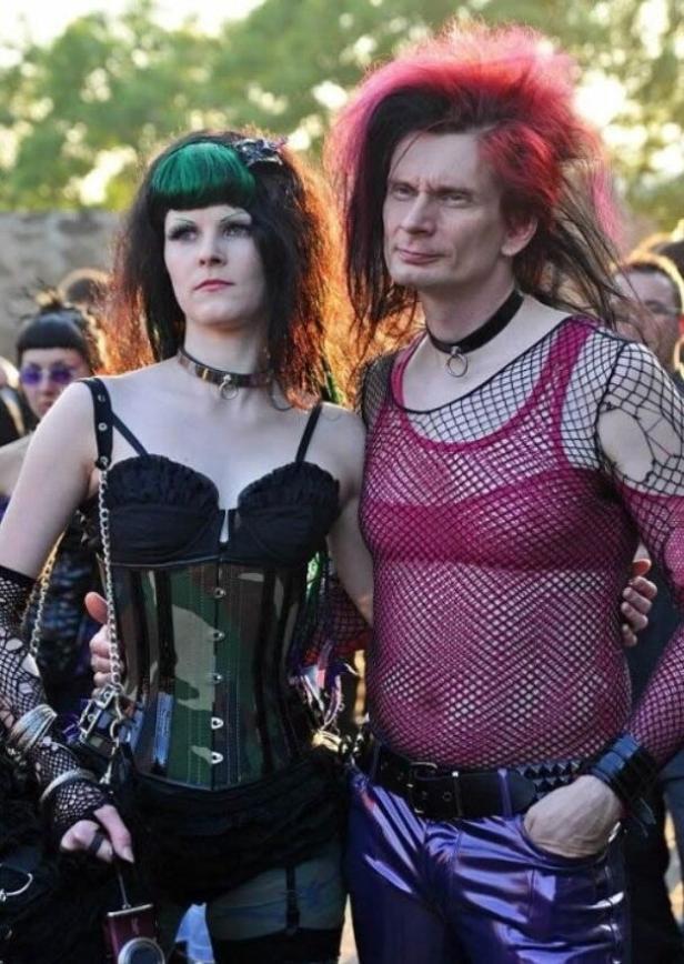 Ein Paar im Gothic-Stil posiert nebeneinander für ein Foto.