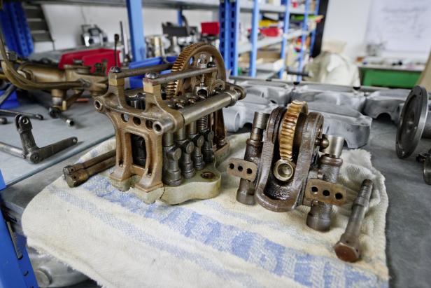 Zwei komplexe, mechanische Baugruppen liegen auf einem Tuch in einer Werkstatt.