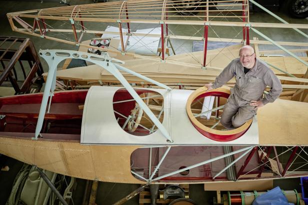 Ein Mann steht in der Rumpföffnung eines im Bau befindlichen Flugzeugs.