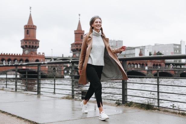 Eine Frau geht vor der Oberbaumbrücke in Berlin spazieren.