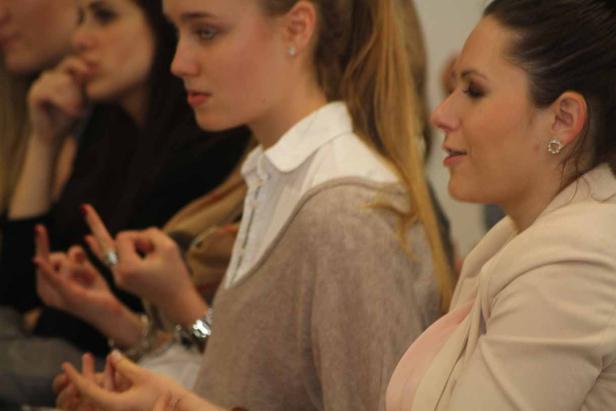 Mehrere Frauen sitzen nebeneinander und scheinen aufmerksam zuzuhören.