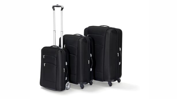 Drei schwarze Stoffkoffer unterschiedlicher Größe stehen nebeneinander.