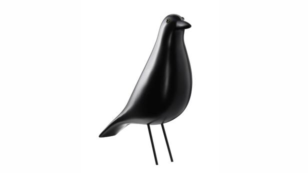 Eine schwarze Vogelstatue steht auf einem weißen Hintergrund.