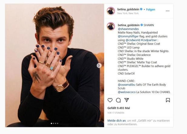 Shawn Mendes präsentiert seine dunkelblau lackierten Fingernägel und Ringe.