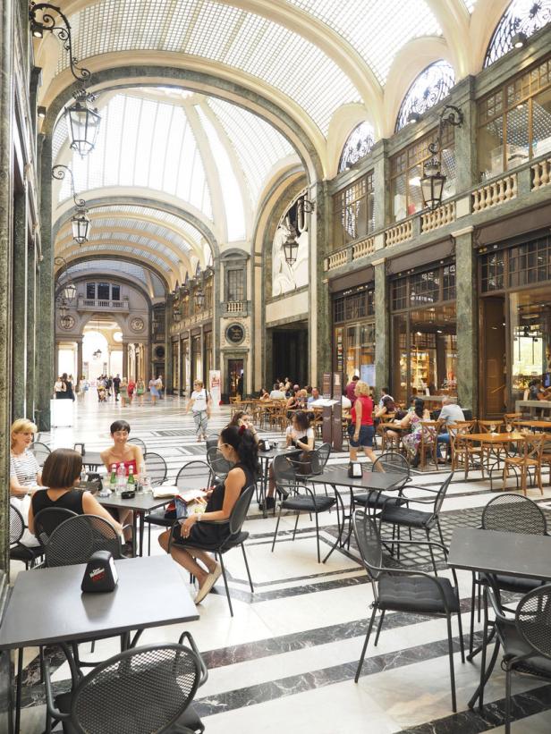 Menschen sitzen in einem Café in der Galleria Vittorio Emanuele III in Neapel.