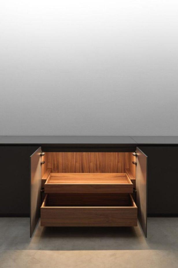 Ein offener Küchenschrank mit zwei Schubladen und Innenbeleuchtung.