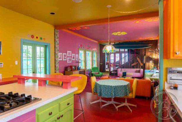 Ein farbenfrohes Interieur mit Küche, Essbereich und Wohnzimmer in verschiedenen Farben.