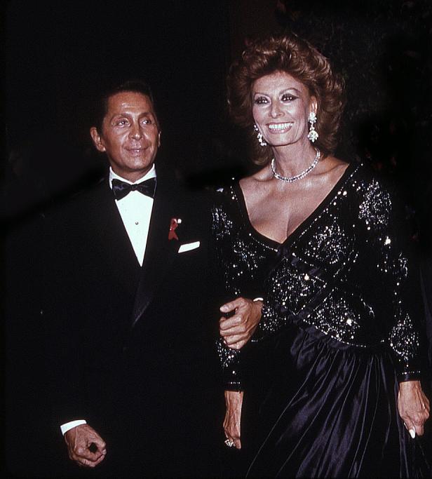 Valentino Garavani und Sophia Loren posieren Arm in Arm.
