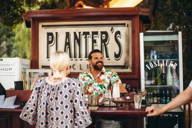 Ein Barkeeper im „Planter's Club“ serviert einer Kundin einen Drink.