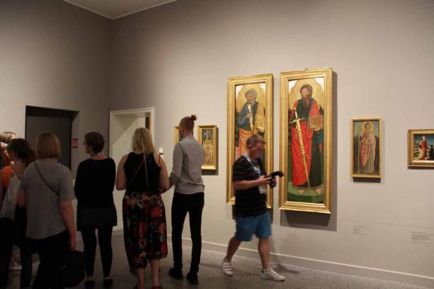 Besucher betrachten Gemälde in einem Kunstmuseum.