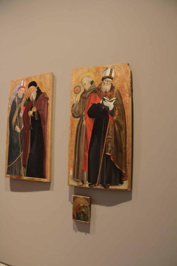 Gemälde von Heiligen und religiösen Figuren an einer Wand.