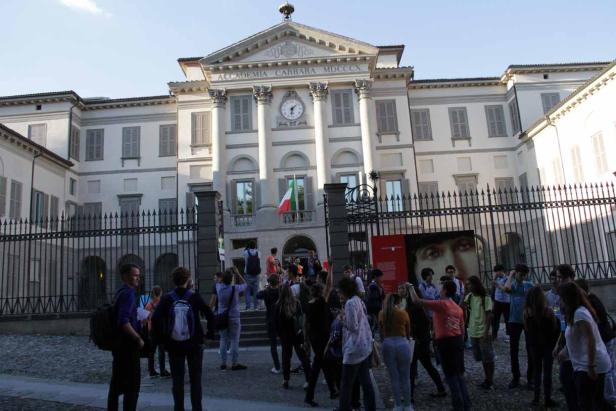 Eine Gruppe von Menschen steht vor der Accademia Carrara in Bergamo.