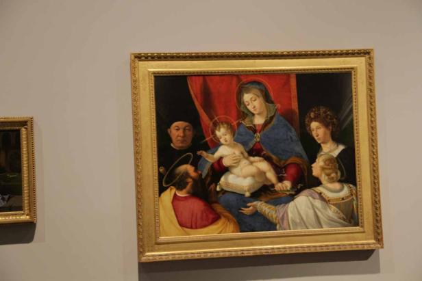 Das Gemälde zeigt Maria mit dem Jesuskind, umgeben von weiteren Personen.