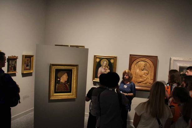 Eine Gruppe von Menschen betrachtet Gemälde in einem Museum.