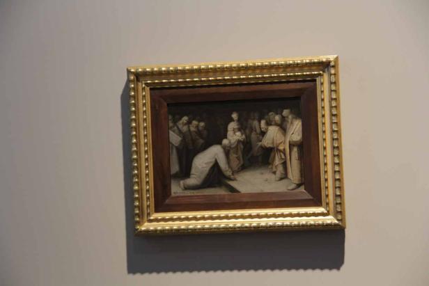 Eine Gemäldedarstellung einer Szene mit einer knienden Person und einer Menschenmenge.