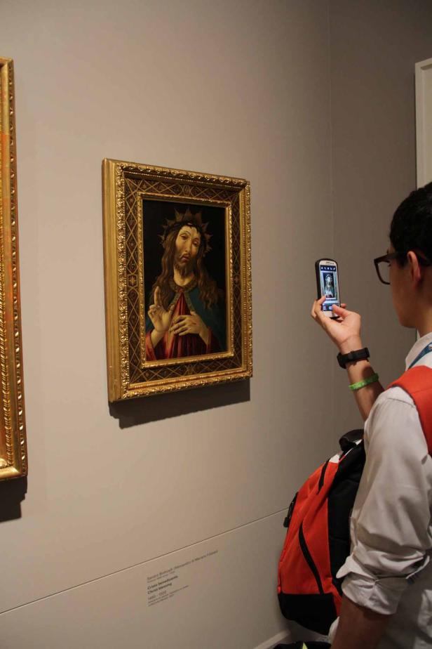Ein Besucher fotografiert „Cristo benedicente“ von Sandro Botticelli.