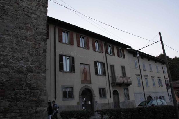 Ein mehrstöckiges Gebäude mit Fensterläden und einem Gemälde an der Fassade.