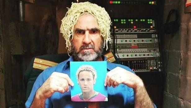 Ein Mann mit Spaghetti auf dem Kopf hält ein Bild von Neymar in den Händen.