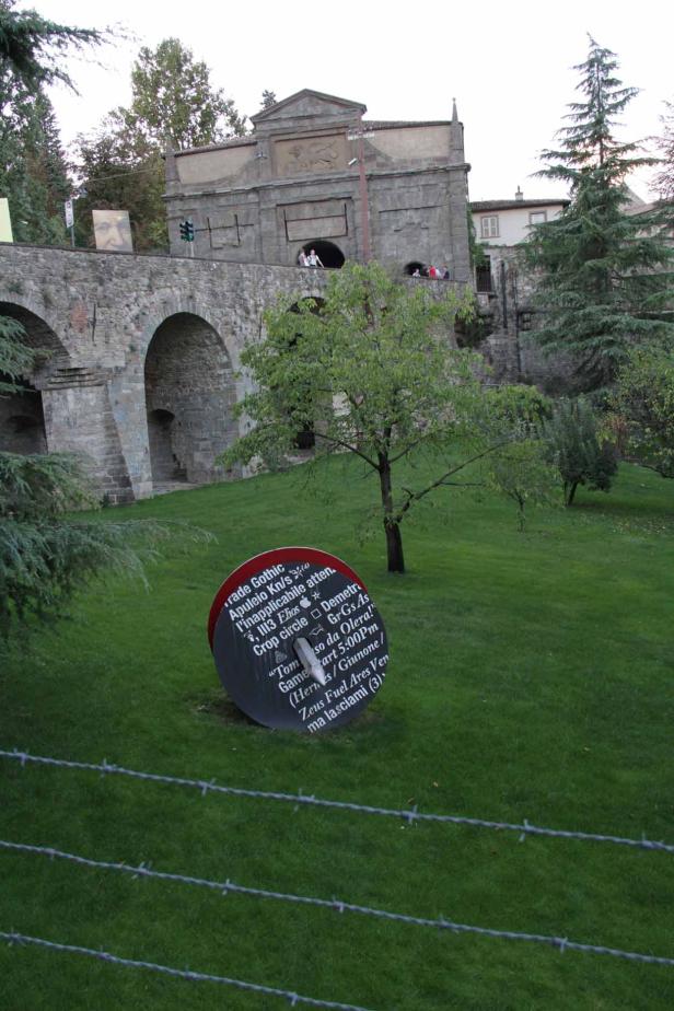 Ein Park mit einer Installation vor einem alten Steintor.