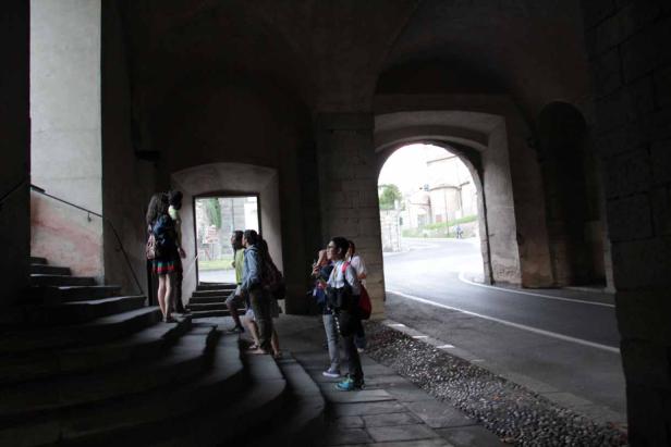 Eine Gruppe von Menschen steht in einem dunklen Torbogen.