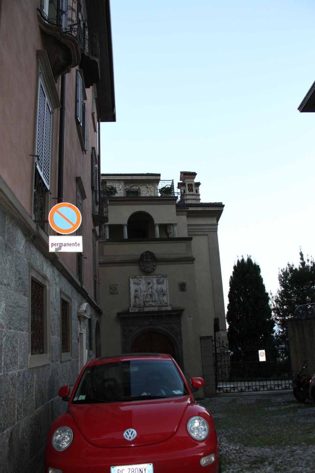 Ein roter VW Käfer parkt vor einem Gebäude mit einem „Einfahrt verboten“-Schild.