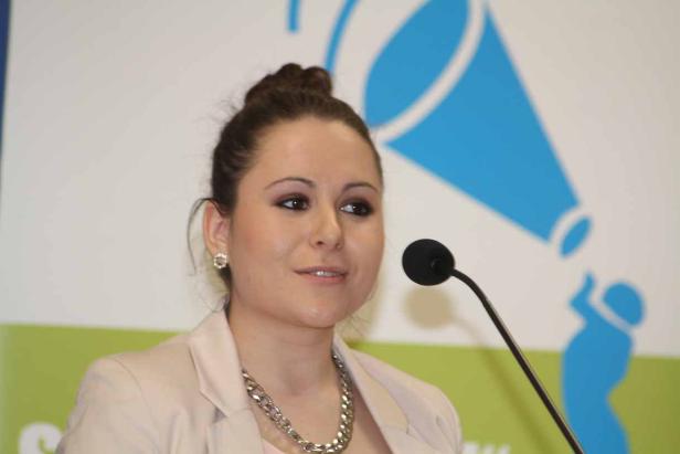 Eine Frau spricht bei einer Veranstaltung in ein Mikrofon.