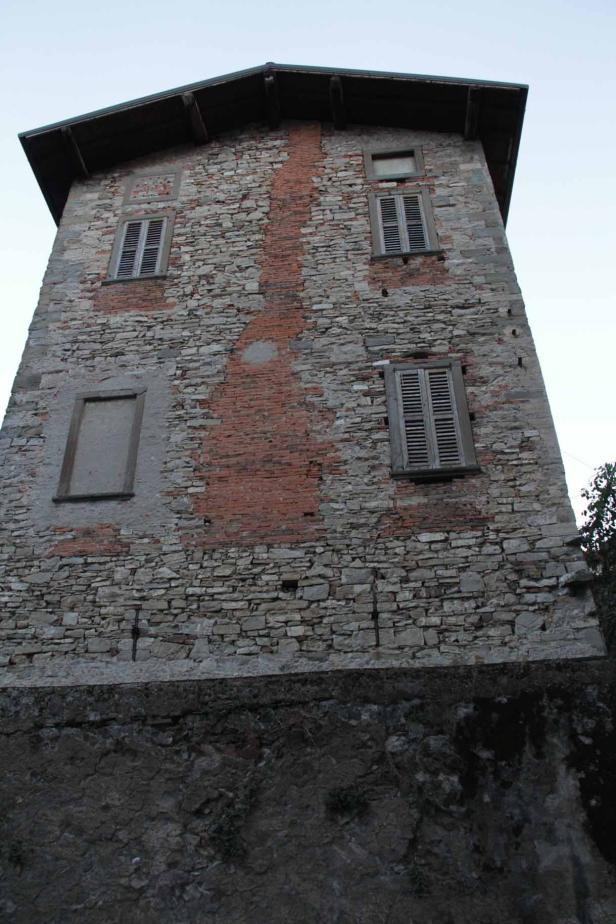 Ein altes, dreistöckiges Steinhaus mit Fensterläden.