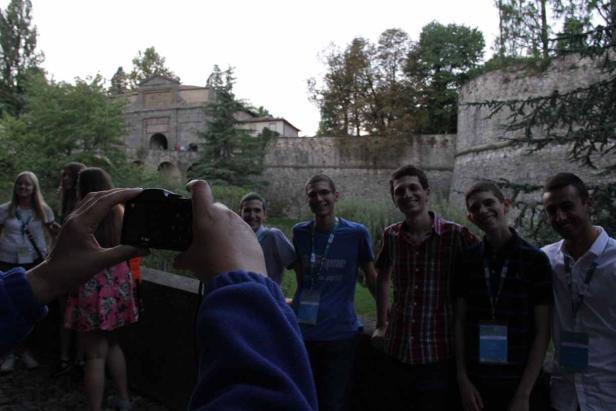 Eine Gruppe junger Leute posiert vor einem alten Stadttor für ein Foto.