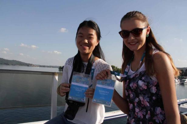 Zwei junge Frauen, Yuan Yuan Emma und Barbora Fedorova, lächeln mit Namensschildern auf einem Schiff.