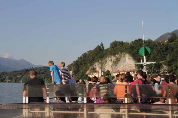 Eine Gruppe von Menschen genießt die Aussicht von einem Boot auf dem See.