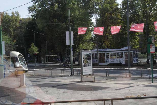 Eine Straßenbahnhaltestelle in Mailand mit einer wartenden Straßenbahn.