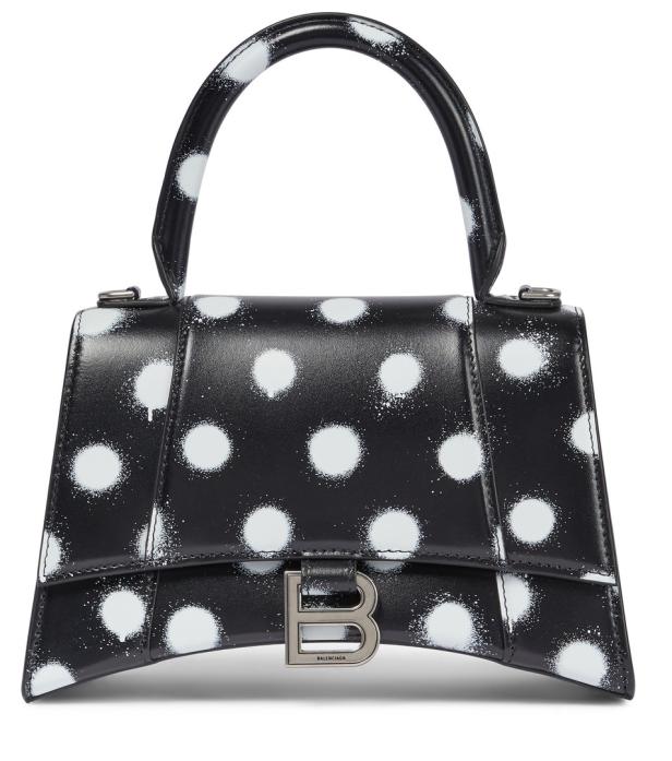 Eine schwarze Balenciaga Handtasche mit weißen Tupfen.